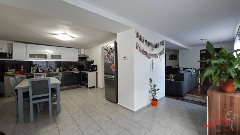 Kitchen with living room in a family house, wooden decor flooring, wall decorations.