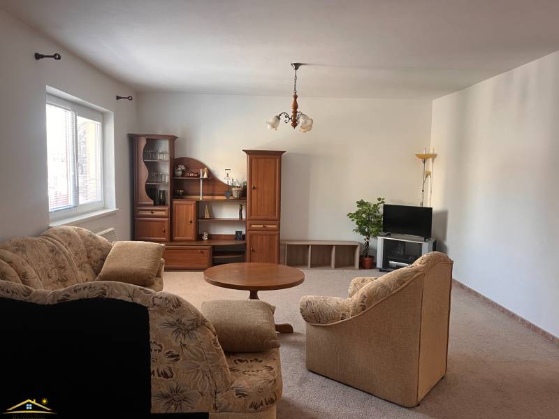Living room in a family house with a couch, wooden furniture, and a television.