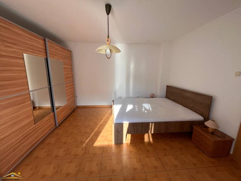 A bedroom in a family house with a large wardrobe and a bed on the floor with a wooden decor.