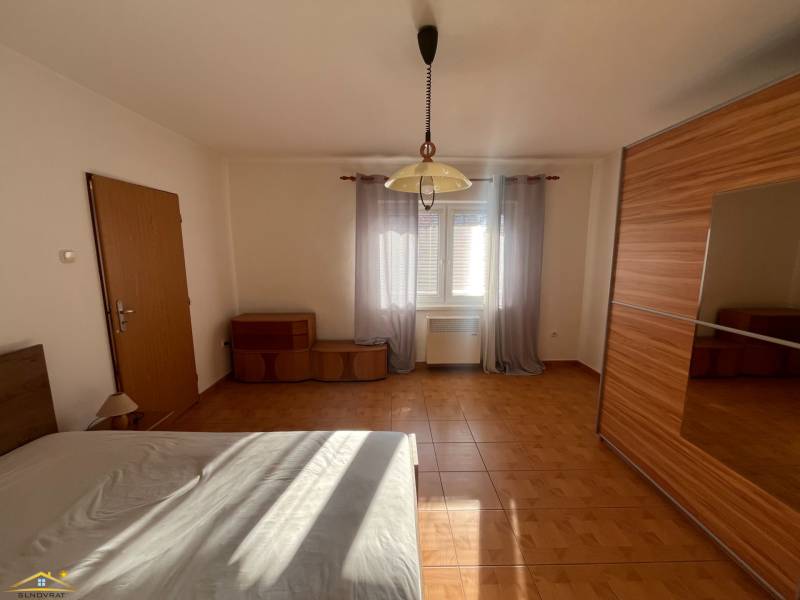 The bedroom dominates in the family house with a wooden decor floor and a large wardrobe.
