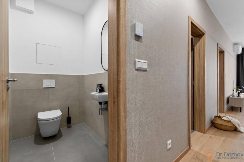 Bathroom in a 2-room apartment with gray tiles and a wooden decor floor.