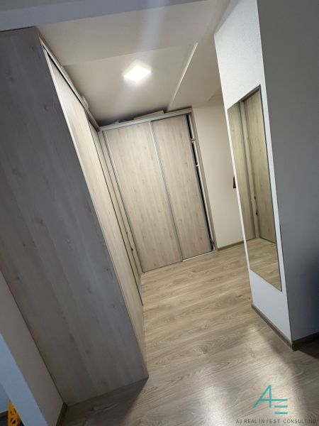 A hallway with a wooden decor floor and a built-in wardrobe in a 2-room apartment.