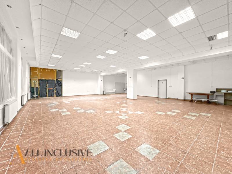 Spacious commercial premises with tiled floors and white walls, suitable for various uses.