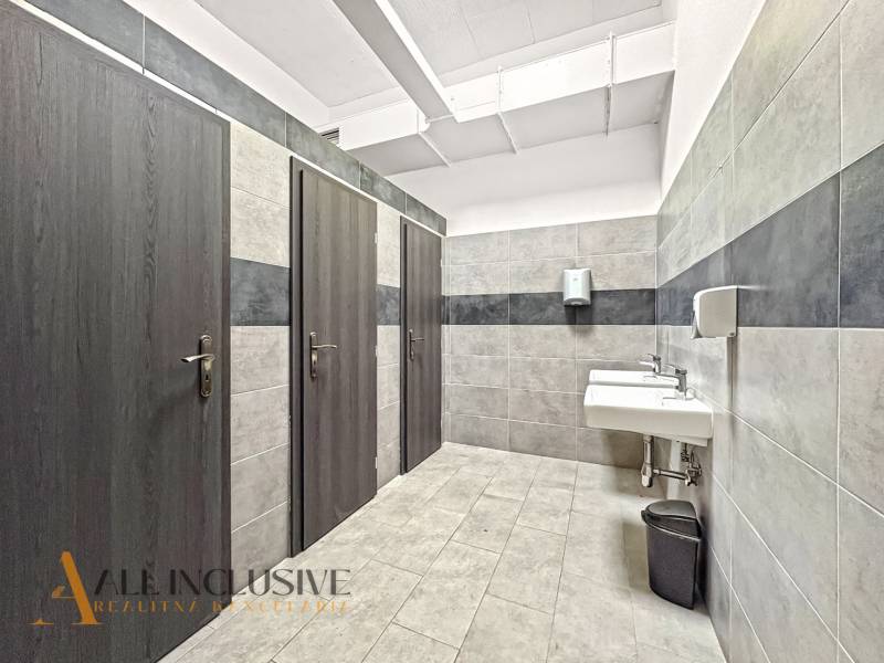 Commercial spaces with sinks and dark doors, floor with wood decor.