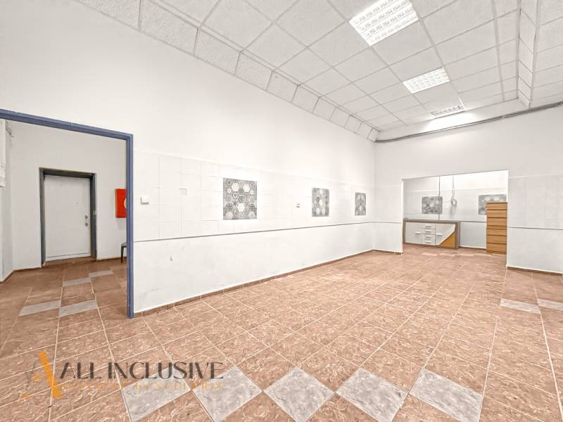 Commercial premises with a tiled floor and high white ceiling.