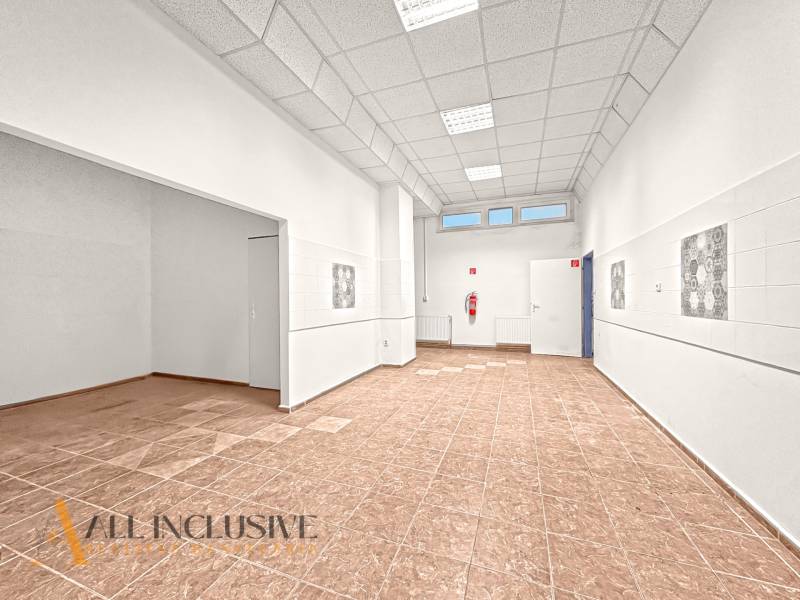 Commercial spaces with wood-patterned flooring and white walls.