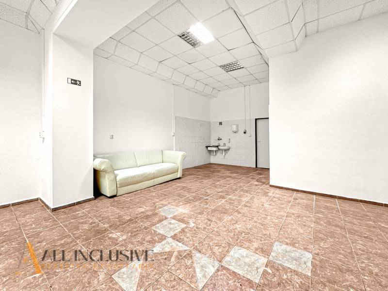 Commercial premises with ceramic flooring, white seating, and a sink.