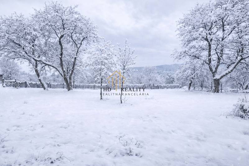 A snowy plot in Stará Huta on Stará Huta 84 street, surrounded by trees and a fence.