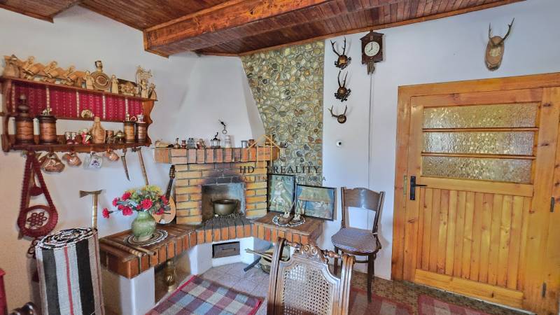 Interior of a family house with a rustic fireplace, decorative furniture, and wooden decorations.