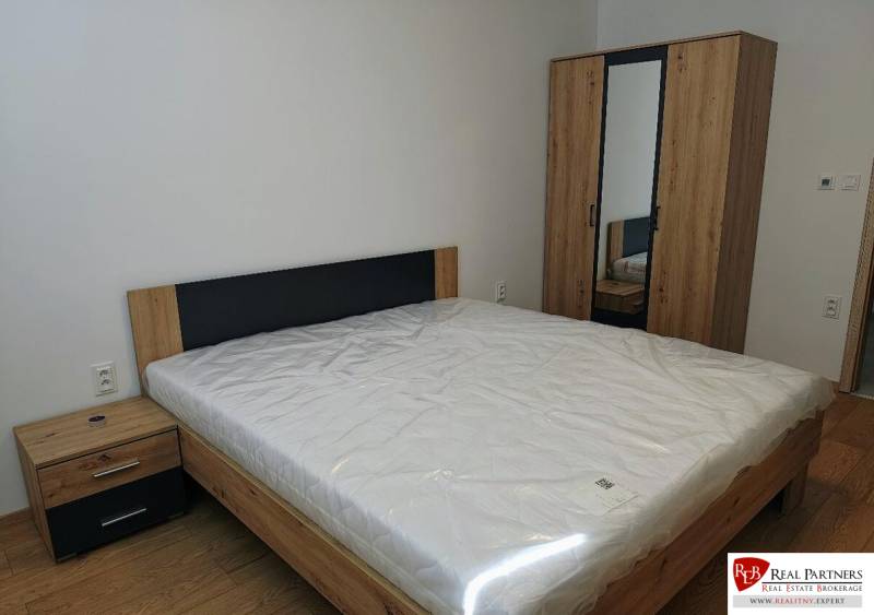 Bedroom with a bed, dresser, and wardrobe in a 3-room apartment, floor with wood decor.