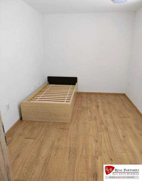 A room in a 3-room apartment with a bed and a floor with a wooden decor.