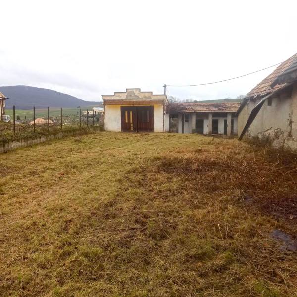A grassy plot near a family house in Nová Bašta with a view of the surrounding countryside.
