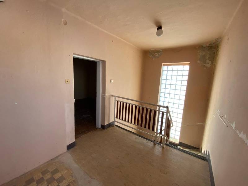 Interior of a family house with a wooden decor floor and a staircase.