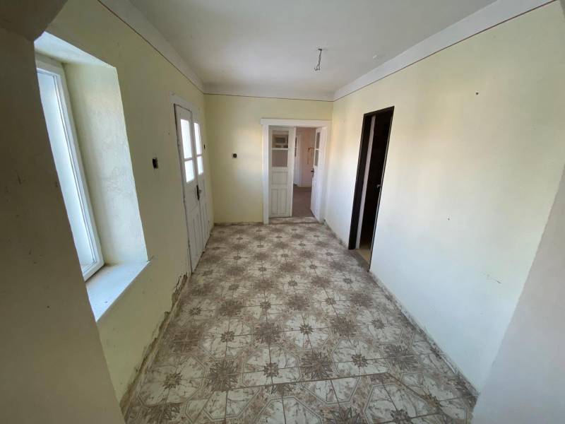 Hallway in a family house with a tiled floor and doors.