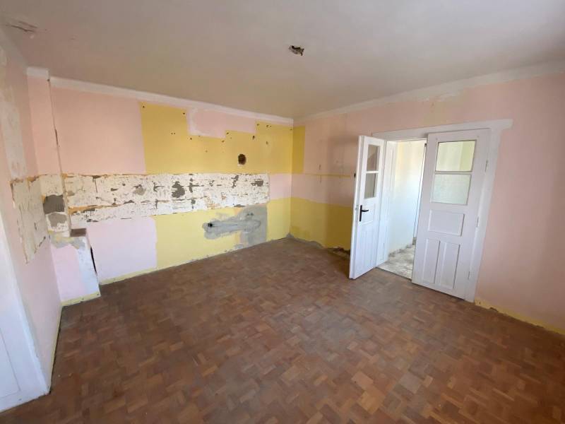 The interior of a family house with a wooden decor floor and colorful walls.