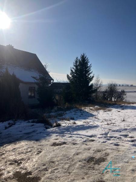 A family house in Rudník on Rudník Street with courtyards covered in winter snow.