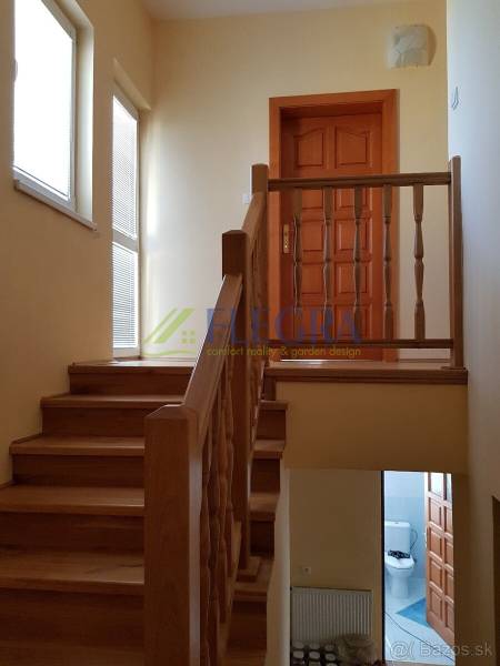 Interior of a family house with a wooden staircase and doors.