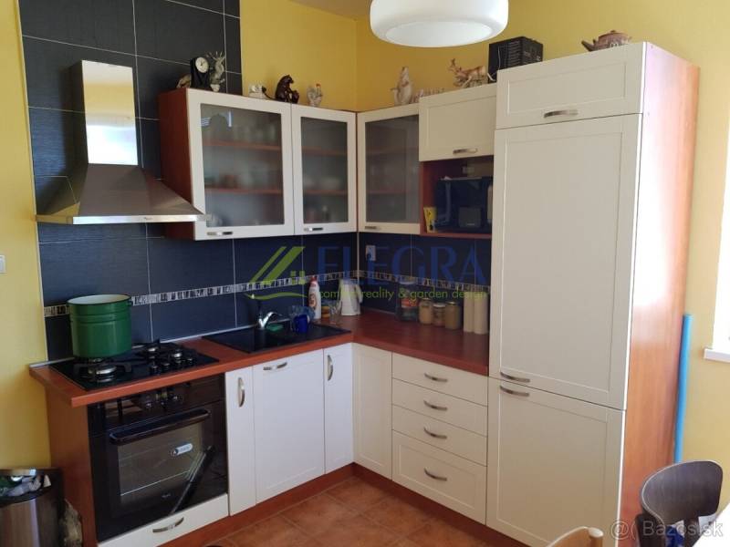 A kitchen unit with an extractor hood and cabinets in a family house.