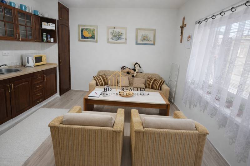 Family house with a cozy living area, kitchen, decorative paintings, and wooden decor flooring.