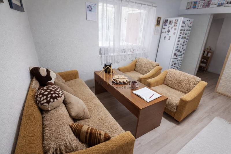 Living room in a family house with a sofa, armchairs, and a coffee table.