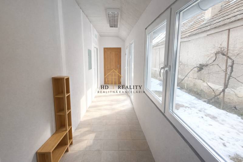 Bright hallway in a family house with a shelf and a view of the snowy exterior.