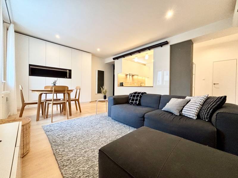 Living room in a 3-room apartment with a wooden decor floor and a comfortable couch.