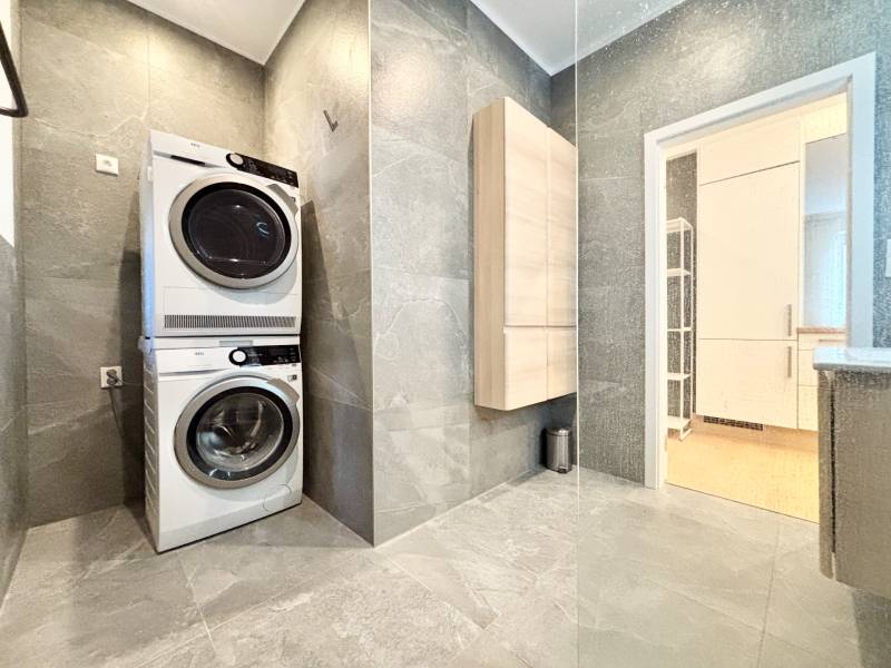 Washing machine with dryer, gray tiles, bathroom in a 3-room apartment.