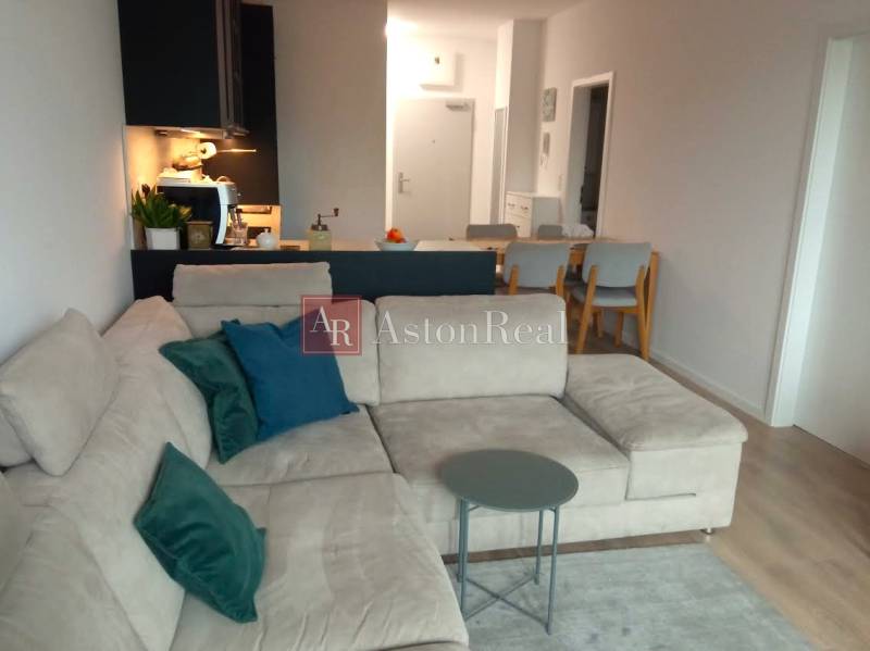 Living room with a sofa and a table in a two-room apartment with a wooden decor floor.