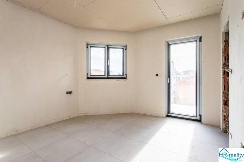 A bright room with a tiled floor and large plastic windows in a 3-room apartment.