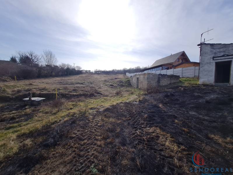 Land on Poľná Street in Banka designated for residential use with a visible structure and fence.