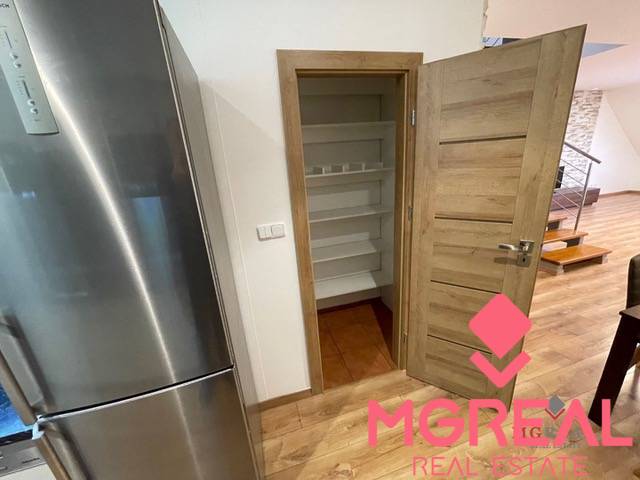 The kitchen in the 3-room apartment includes a refrigerator, a pantry, and a floor with a wooden decor.