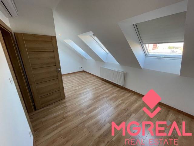 Attic room with skylights and a floor with wood decor in a 3-room apartment.