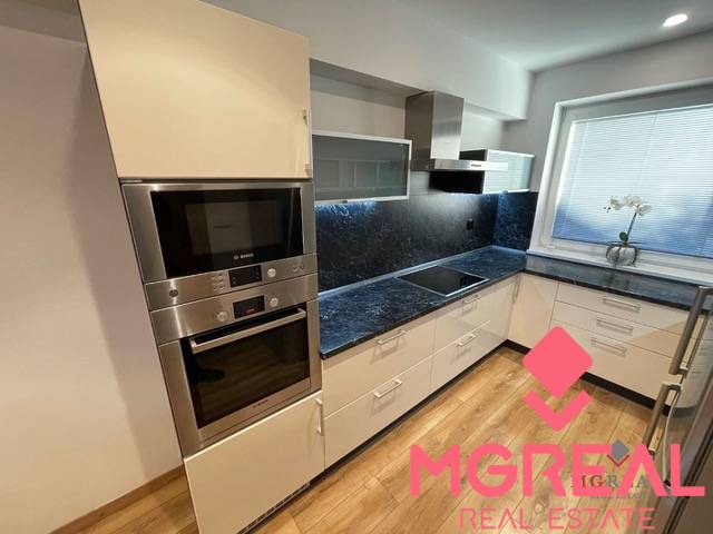 A kitchen in a 3-room apartment with white cabinets and a wood-patterned floor.