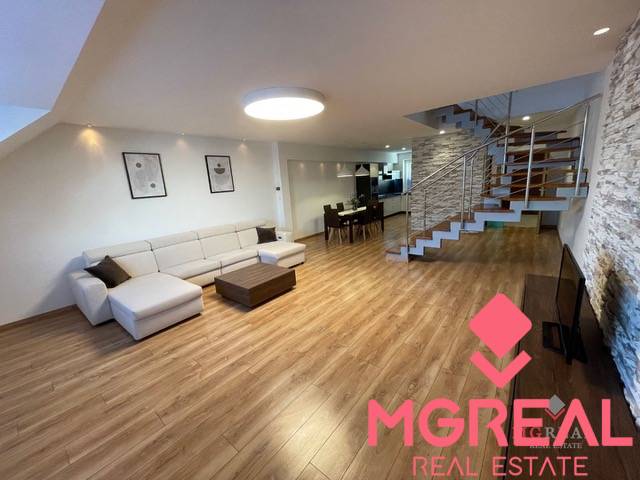 Living room in a 3-room apartment with a wooden decor floor and a designer staircase.