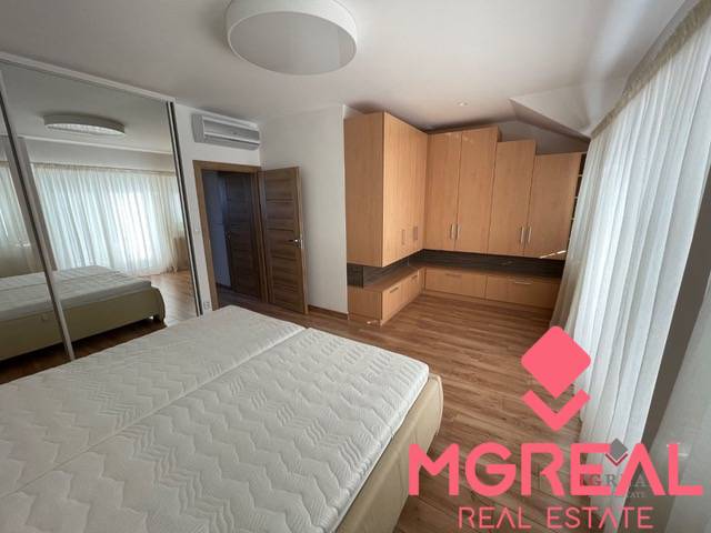 Bedroom with a bed, built-in wardrobe, and wooden decor flooring in a 3-room apartment.