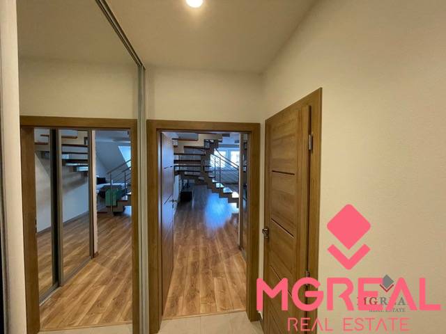 Interior of a 3-room apartment with a wooden decor floor and a staircase.