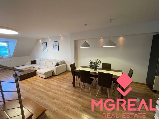 Living room in a three-room apartment with a wooden decor floor, dining table, and sofa.