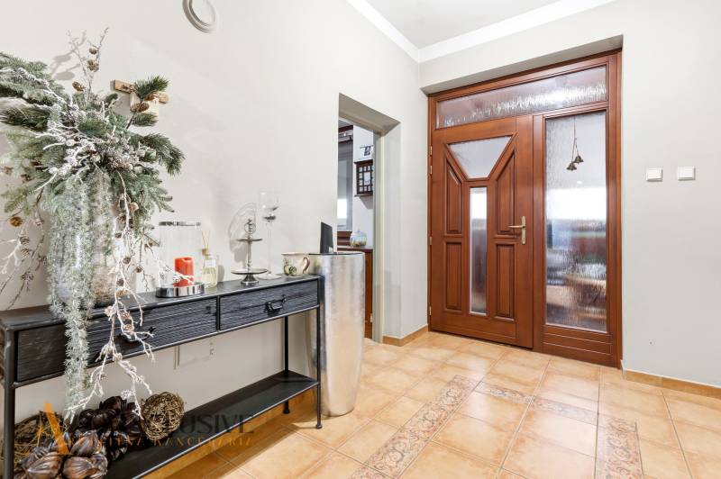 Entrance hall in a family house with wooden doors and decorative furniture on the floor.