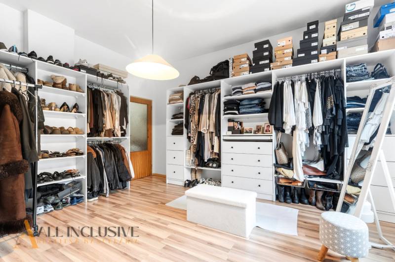 Wardrobe with clothes and shoes, floor with wooden decor, family house.
