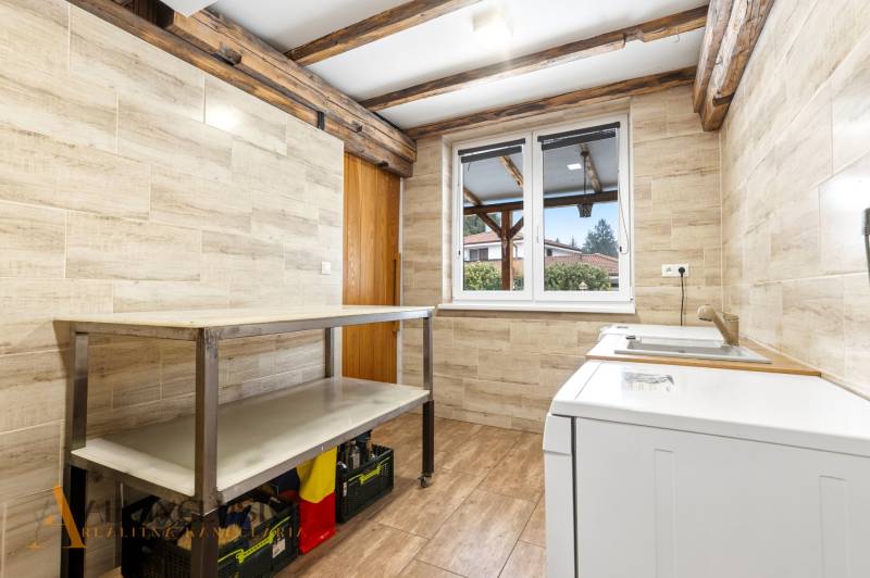 Laundry room in a family house with wood-patterned tiles and flooring.