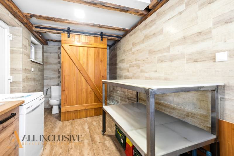 Laundry room in a family house with wooden sliding doors and a floor with a wooden decor.