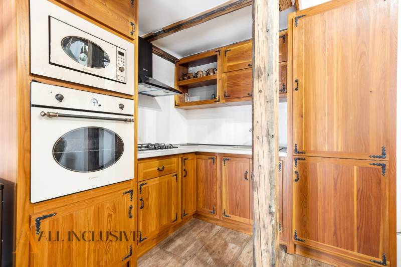 Rustic kitchen in a family house with wooden cabinets and a wooden decor floor.