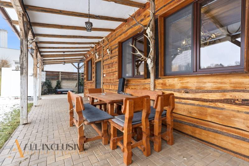 Wooden terrace of a family house in Dolný Štál, with seating and brick paving.