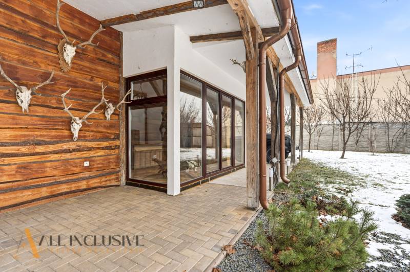 The exterior of a family house in Dolný Štál with decorative skulls on the wooden wall.