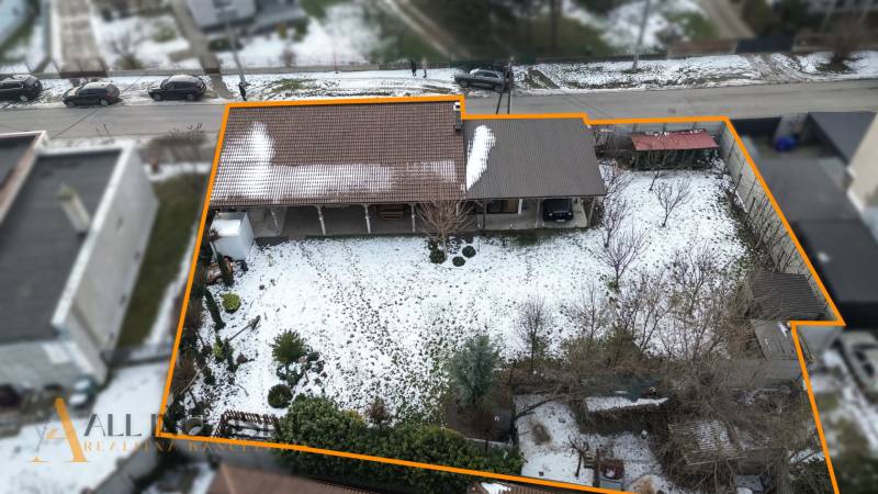 A snow-covered plot of land near a family house in Dolný Štál with a garage and a garden.