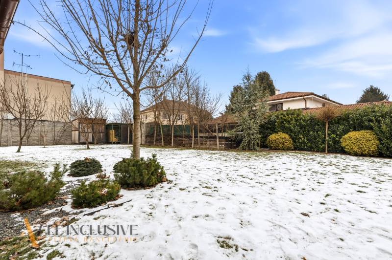 A snow-covered garden with leafless trees near a family house in Dolný Štál.
