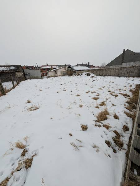 A snow-covered plot of land in Ľubica on Remeselnícka Street, surrounded by family houses.