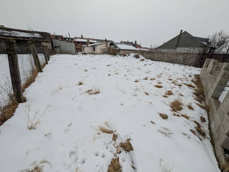 A snowy plot on Remeselnícka Street in Ľubica surrounded by family houses.
