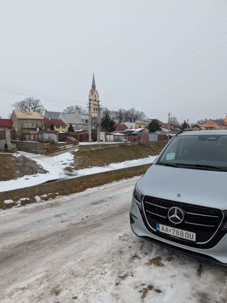 A view of the snow-covered Remeselnícka Street in Ľubica with family houses and a car.