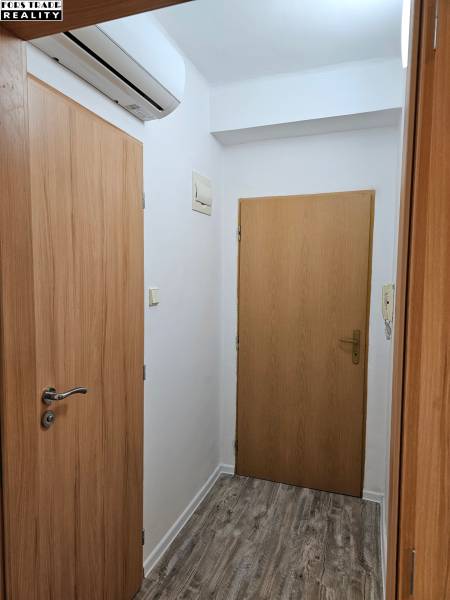 Wooden door, air conditioning, and floor with wooden decor in the office.